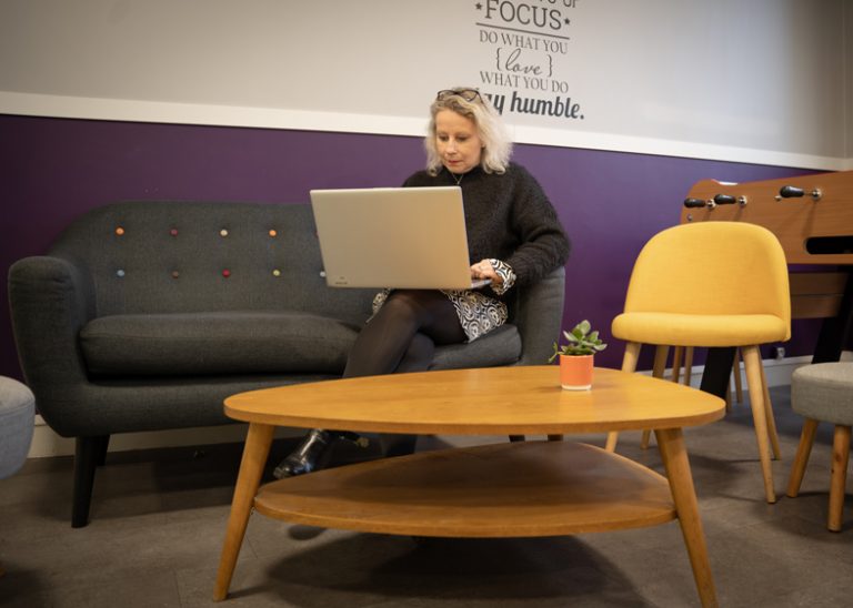 Femme installée sur un canapé dans les locaux du groupe Fitec